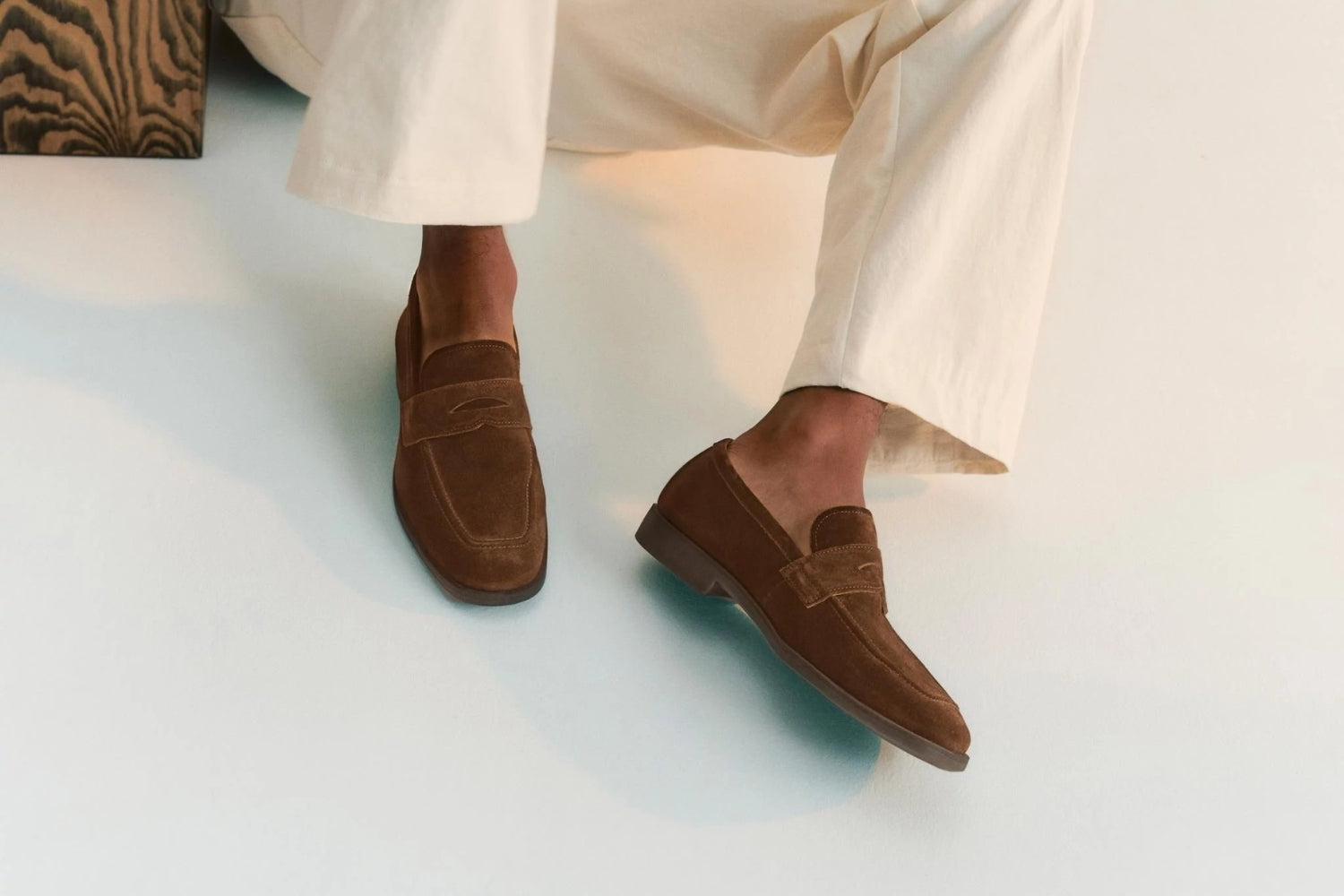 Ruskeat mokkanahkaiset loaferit miehen jaloissa.