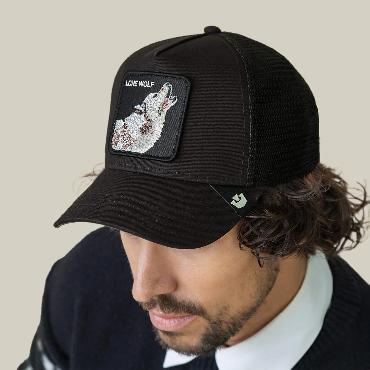 Goorin Bros lippis Lone Wolf Trucker, musta, jossa musta verkkoinen takakappale ja edessä brodeerattu harmaa susikuvio sekä säädettävä takakiinnitys.