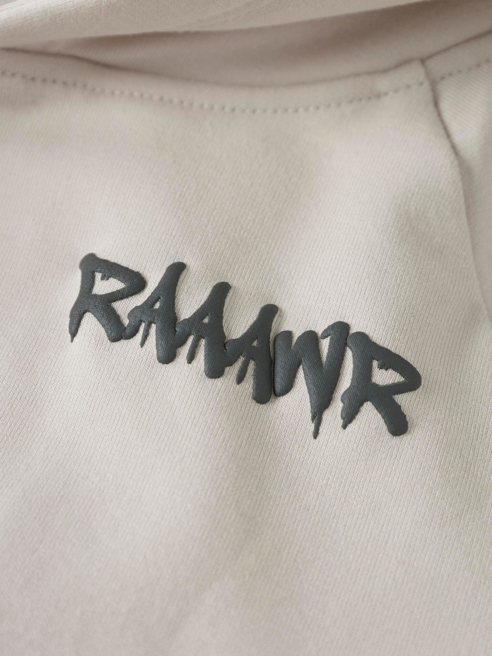 Name It lasten huppari NMMBENTU LS NREG, beige, jossa pehmeä puuvillainen kangas ja kohokuvioitu tummanharmaa teksti rintamuksessa.