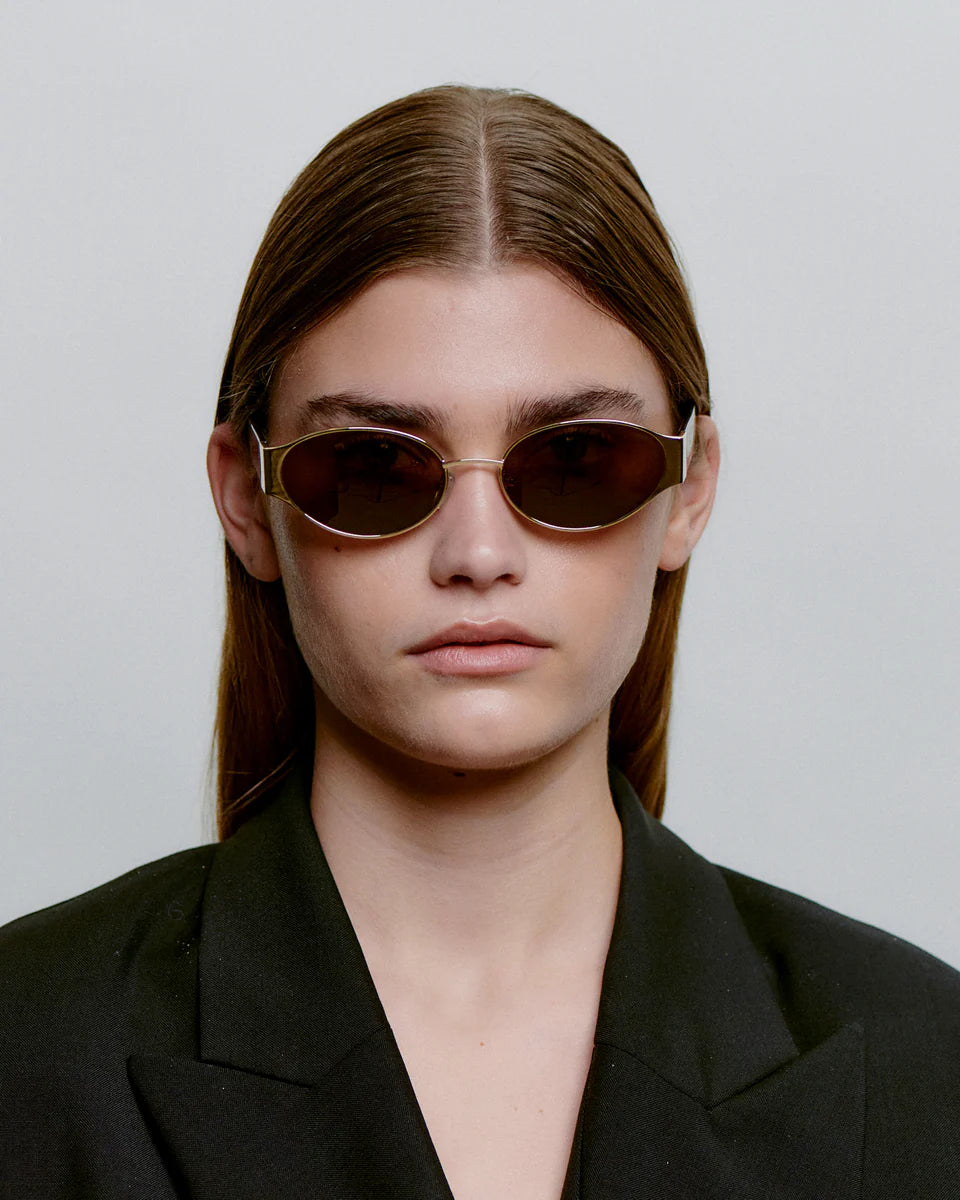A.Kjaerbede unisex aurinkolasit Bella, Kulta, ohut kullanvärinen kehys ja tummat soikeat linssit, minimalistinen ja ajaton unisex-malli.