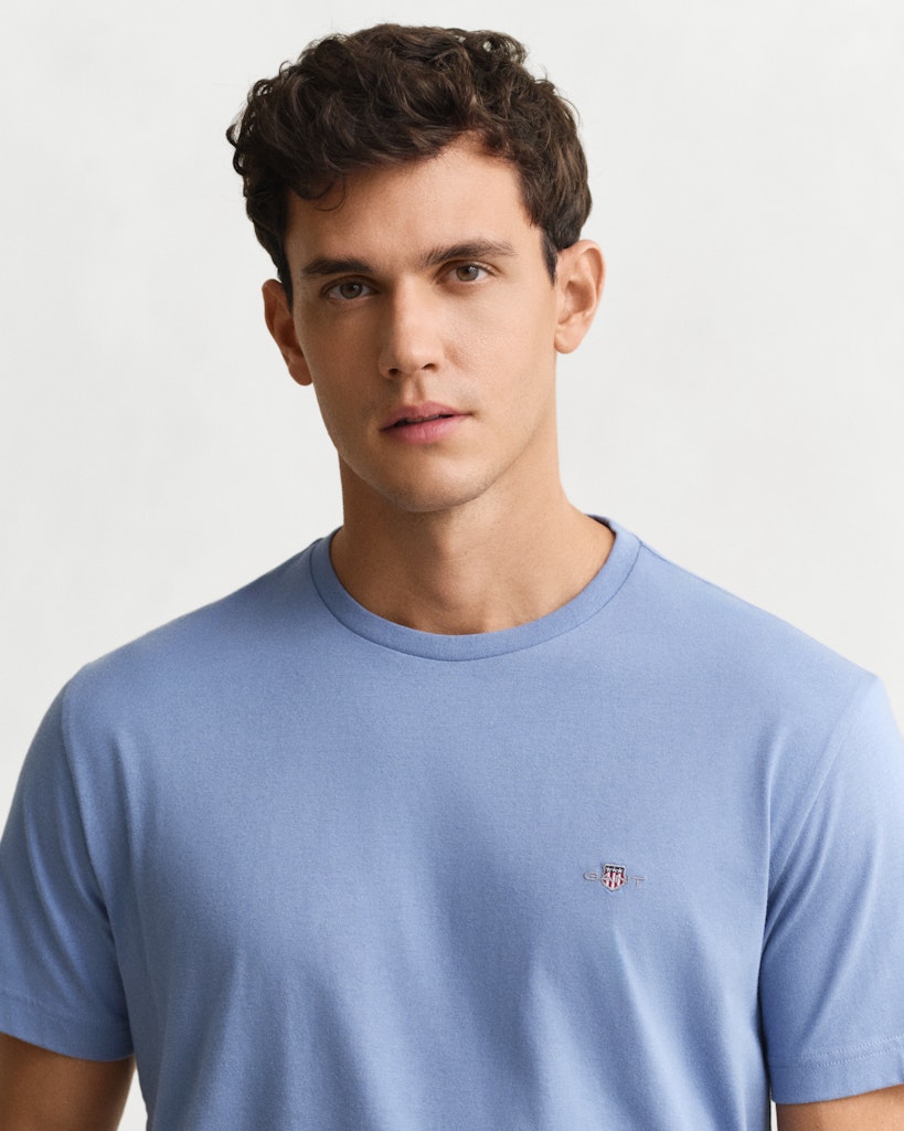 Gant miesten t-paita Reg Shield SS T-shirt, keskisininen, puuvillainen lyhythihainen t-paita, pyöreä resoripääntie ja pieni vaakunakirjailu rinnassa