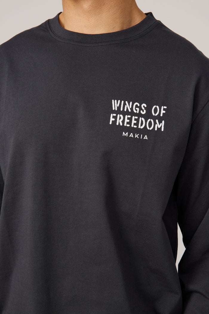 Makia miesten pitkähihainen paita Wings Long Sleeve, musta, jossa on pyöreä pääntie, rento istuvuus ja edessä valkoinen painatus tekstillä Wings of Freedom.