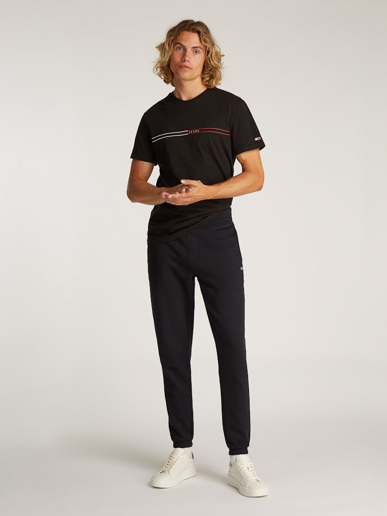 tommy-jeans-miesten-collegehousut-tjm-slim-s-flag-sweatpant-ext-musta-1