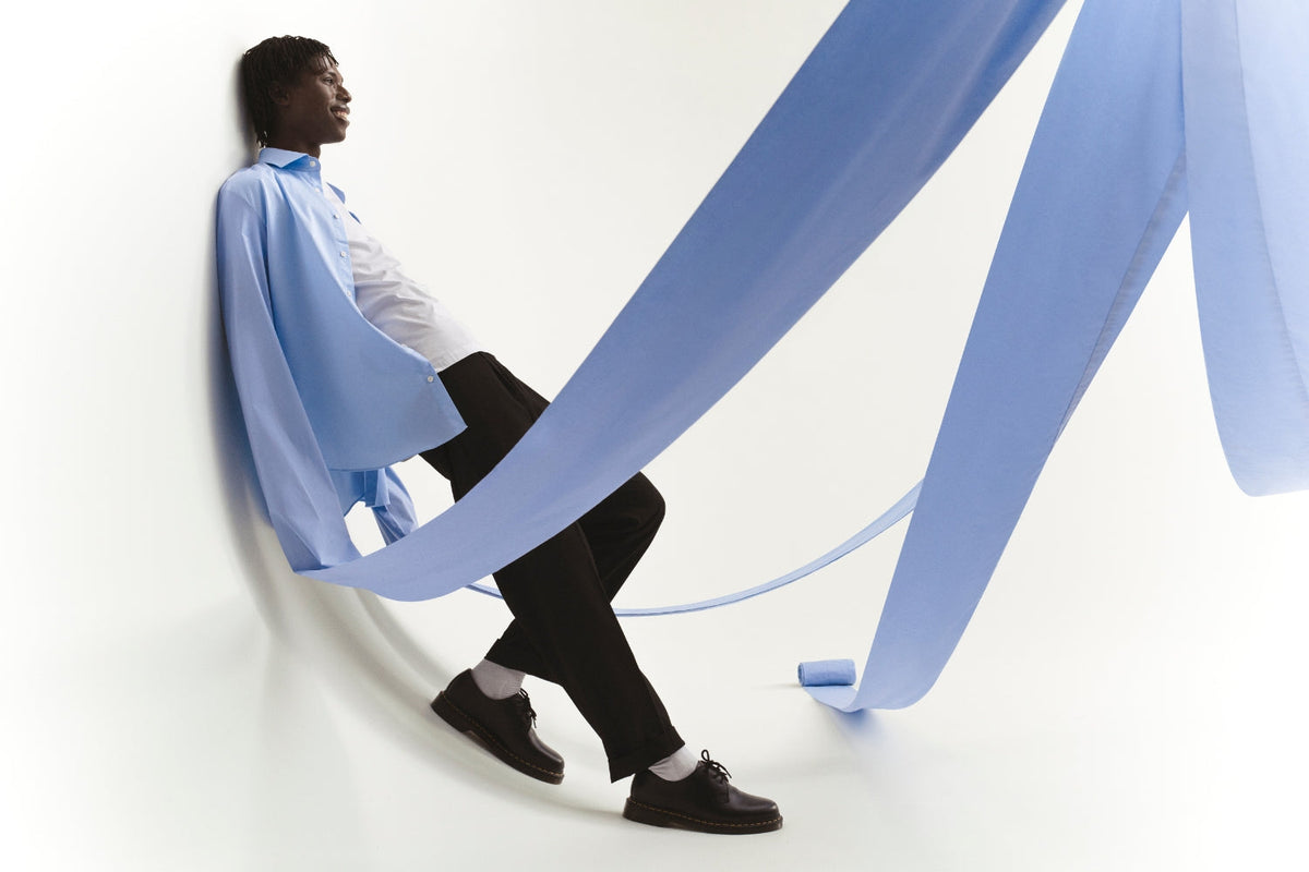 Miehellä on päällään kauluspaita, jossa on metrejä pitkät hihat.