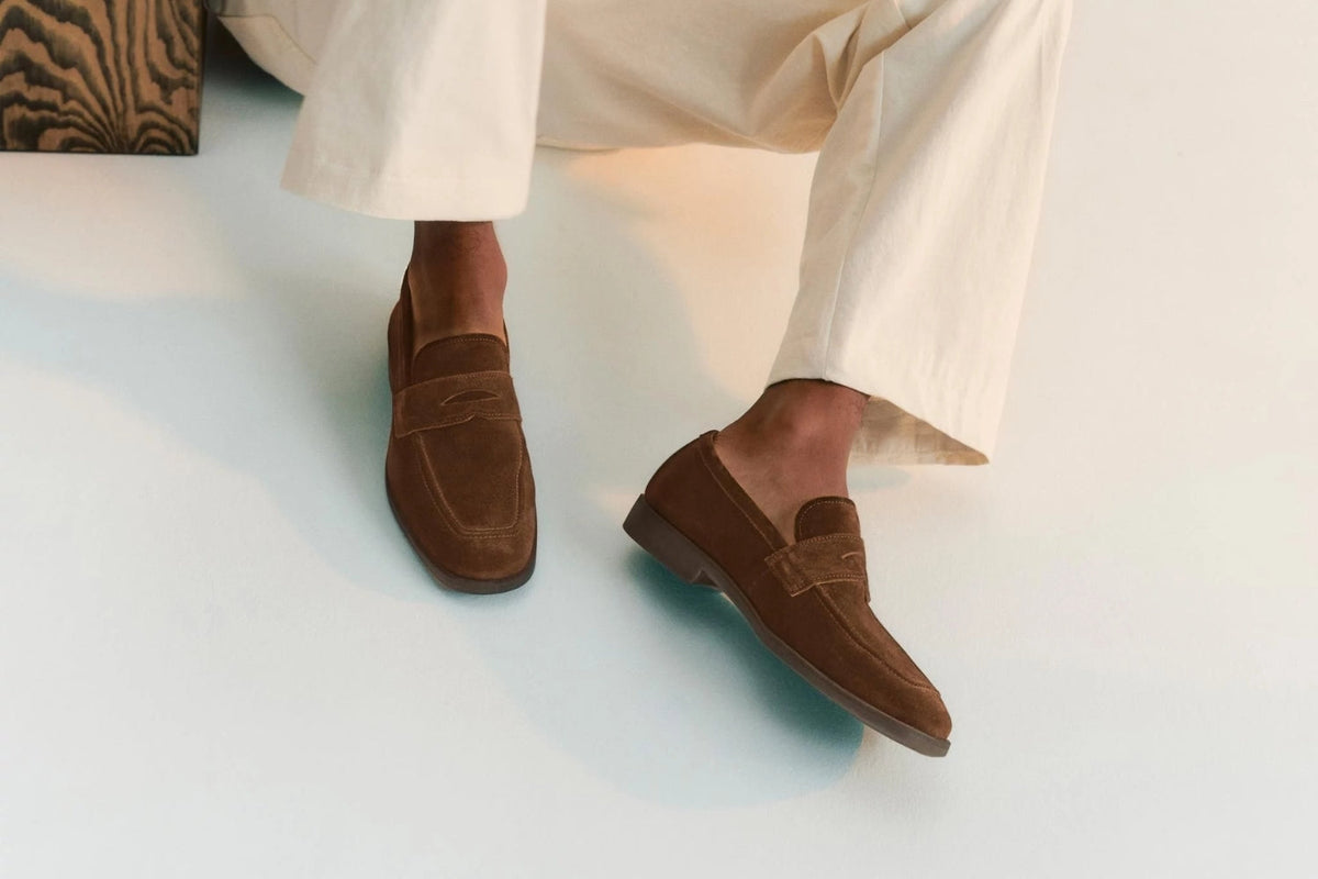 Ruskeat mokkanahkaiset loaferit miehen jaloissa.