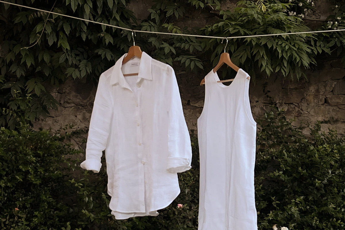 Pellavavaatteet henkareilla pyykkinarulla.