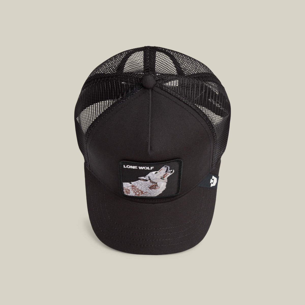 Goorin Bros lippis Lone Wolf Trucker, musta lippis mustalla umpikankaalla edessä ja verkkomateriaalilla takana, jossa kirjottu susiaiheinen kuviointi etupaneelissa.