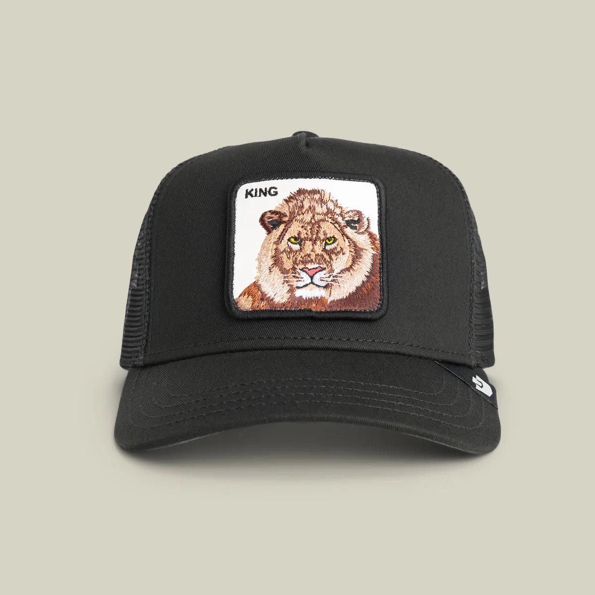 Goorin Bros lippis Lion King Trucker, musta, jossa musta verkkopäällysteinen takaosa ja edessä kirjailtu leijonakuvio, muotoiltu lippa ja säädettävä tarrakiinnitys.