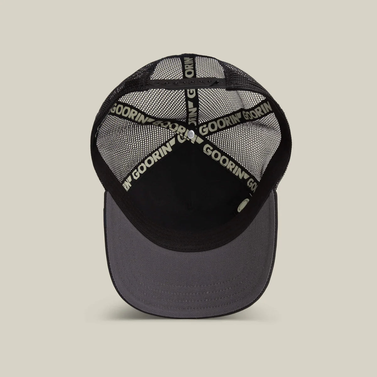 Goorin Bros lippis Wise Ass Owl Trucker, musta, jossa musta verkkopäinen rakenne, tummanharmaa lippa ja mustat koristeteipit painatuksella.