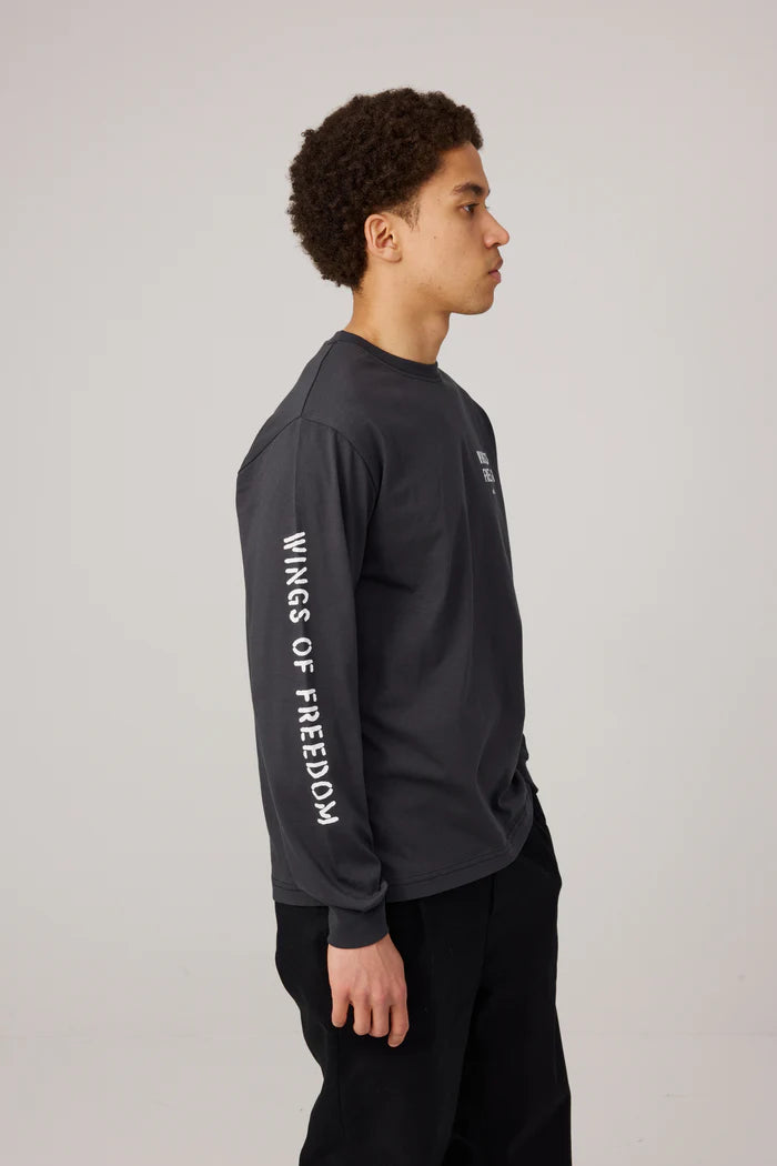 Makia miesten pitkähihainen paita Wings Long Sleeve, musta, suoraleikkauksella, pyöreällä pääntiellä, pehmeää ja laadukasta materiaalia, valkoiset printit hihassa ja rinnassa.